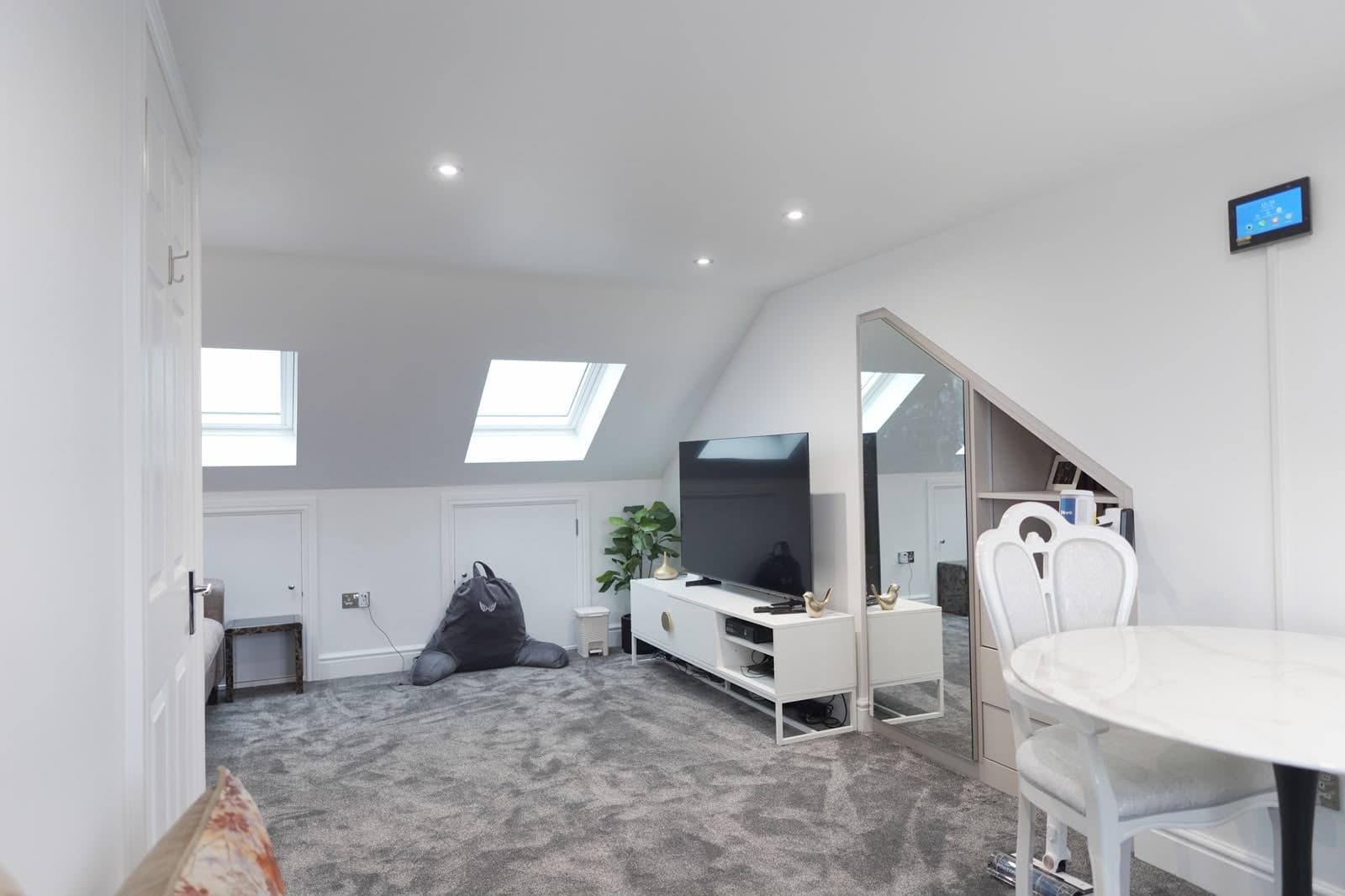Finished loft room with two rooflights, eaves storage and grey carpet